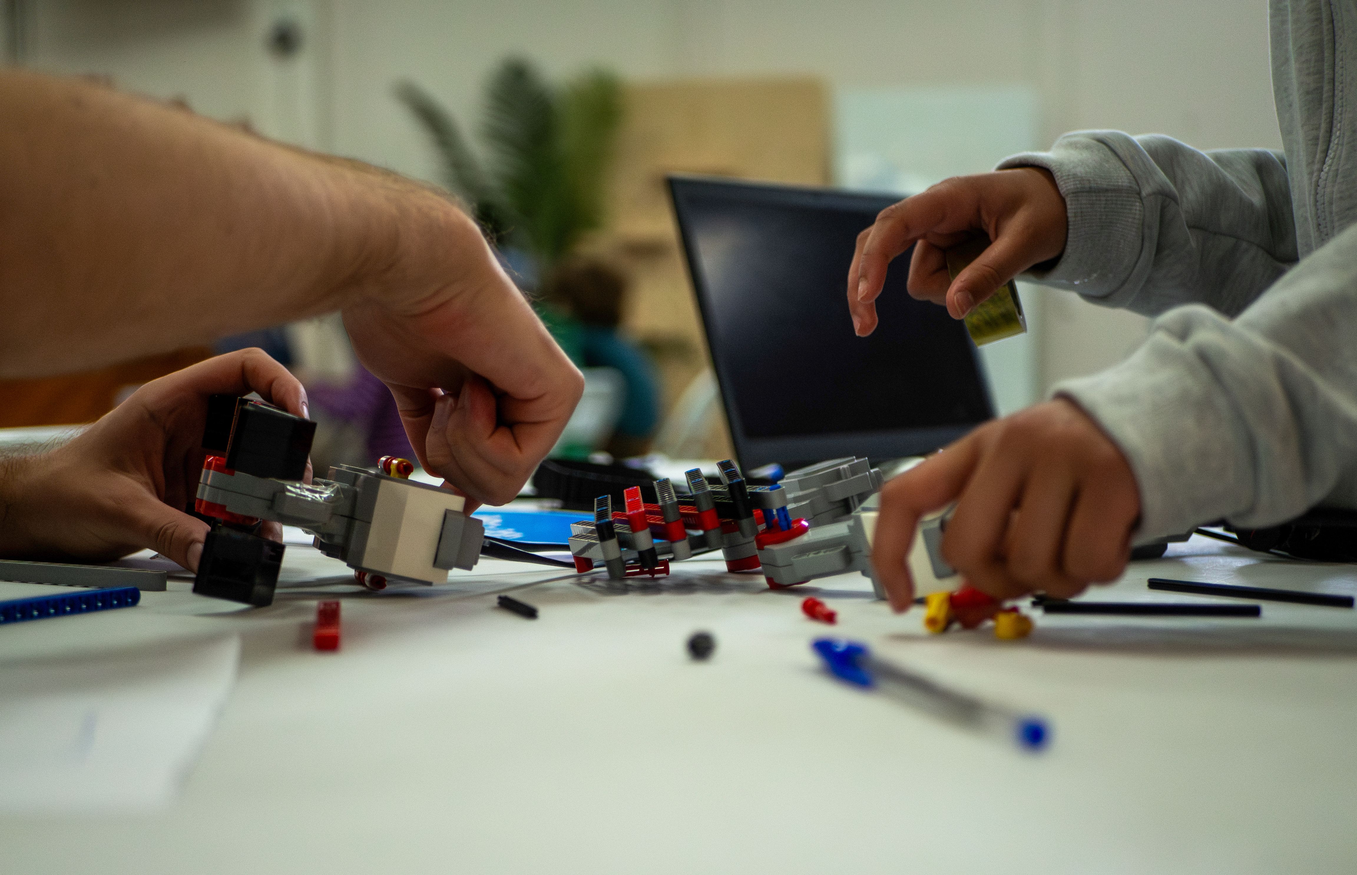 A mentor and attendee working together on a LEGO robot
