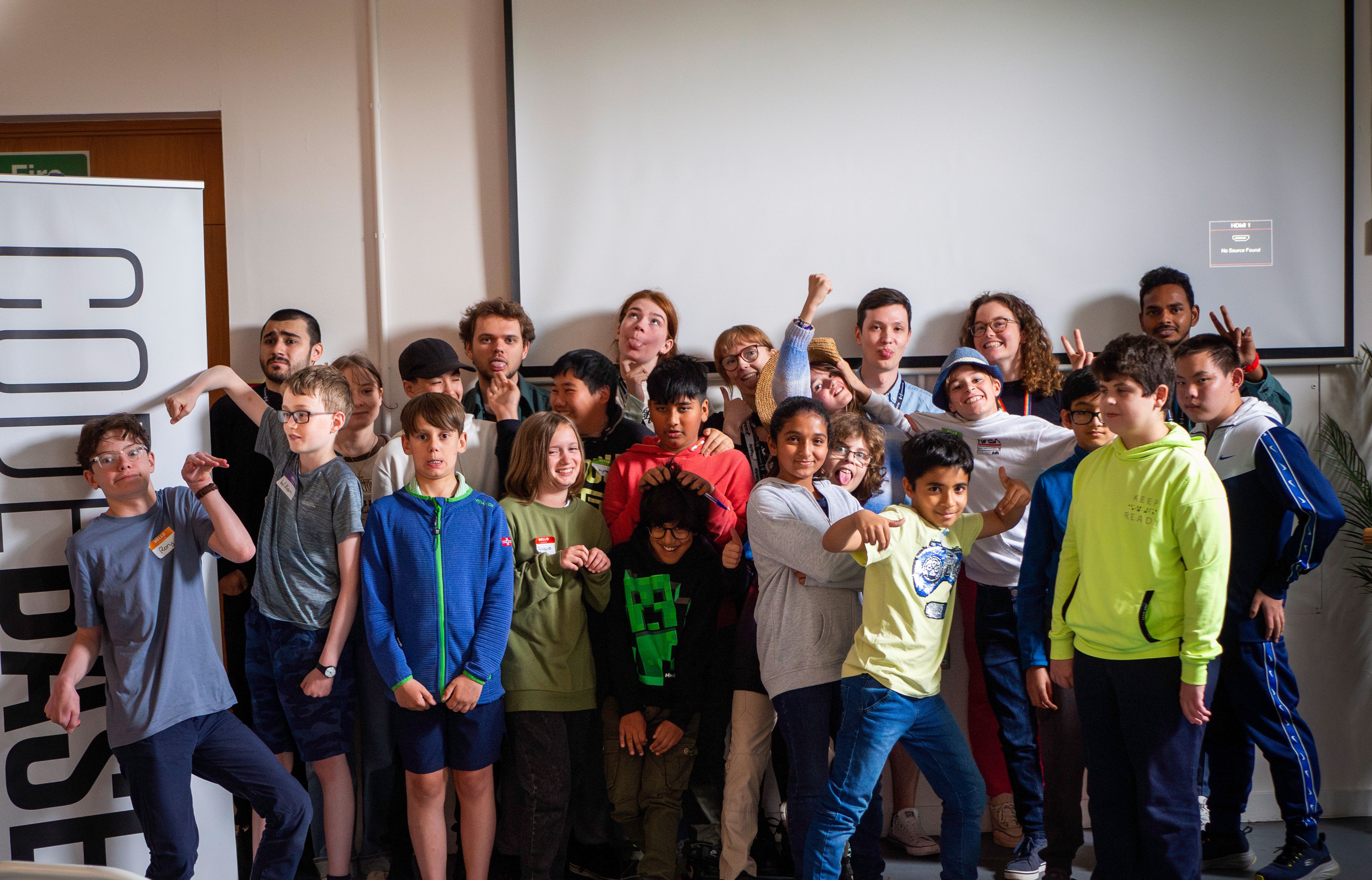 A large group of mentors and attendees making silly faces at the camera