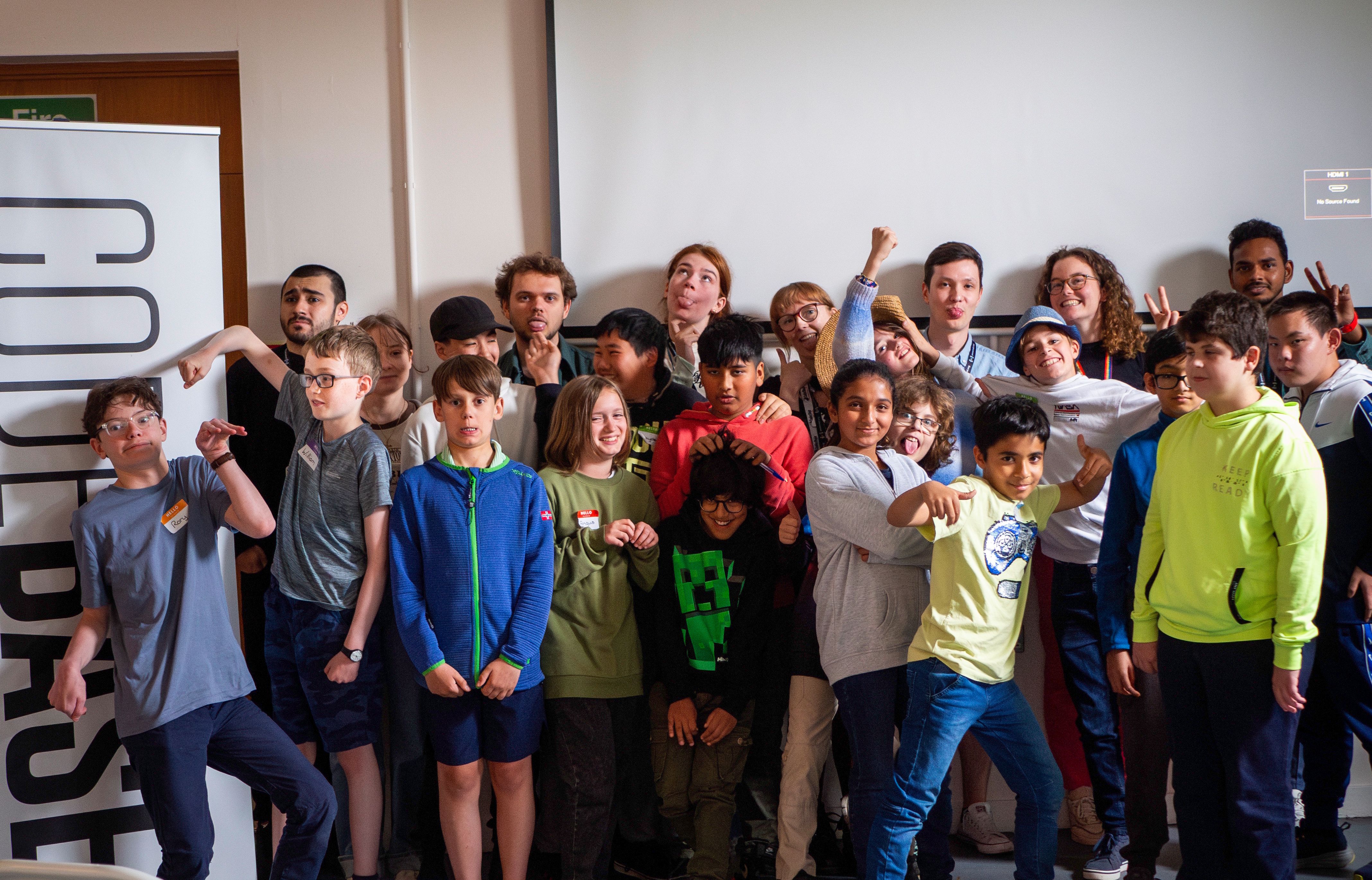 A large group of mentors and attendees making silly faces at the camera