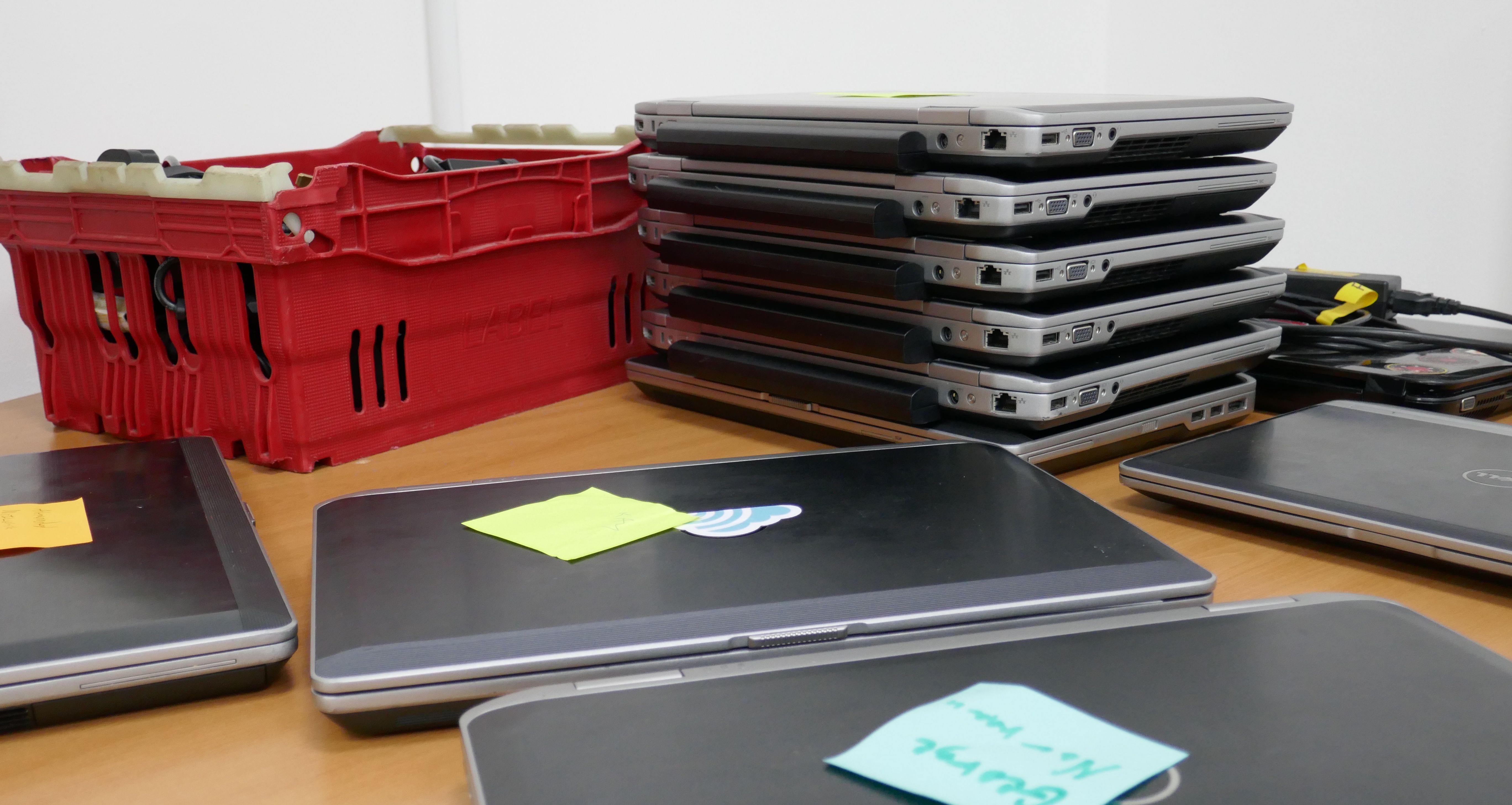 A stack of Prewired laptops on a table