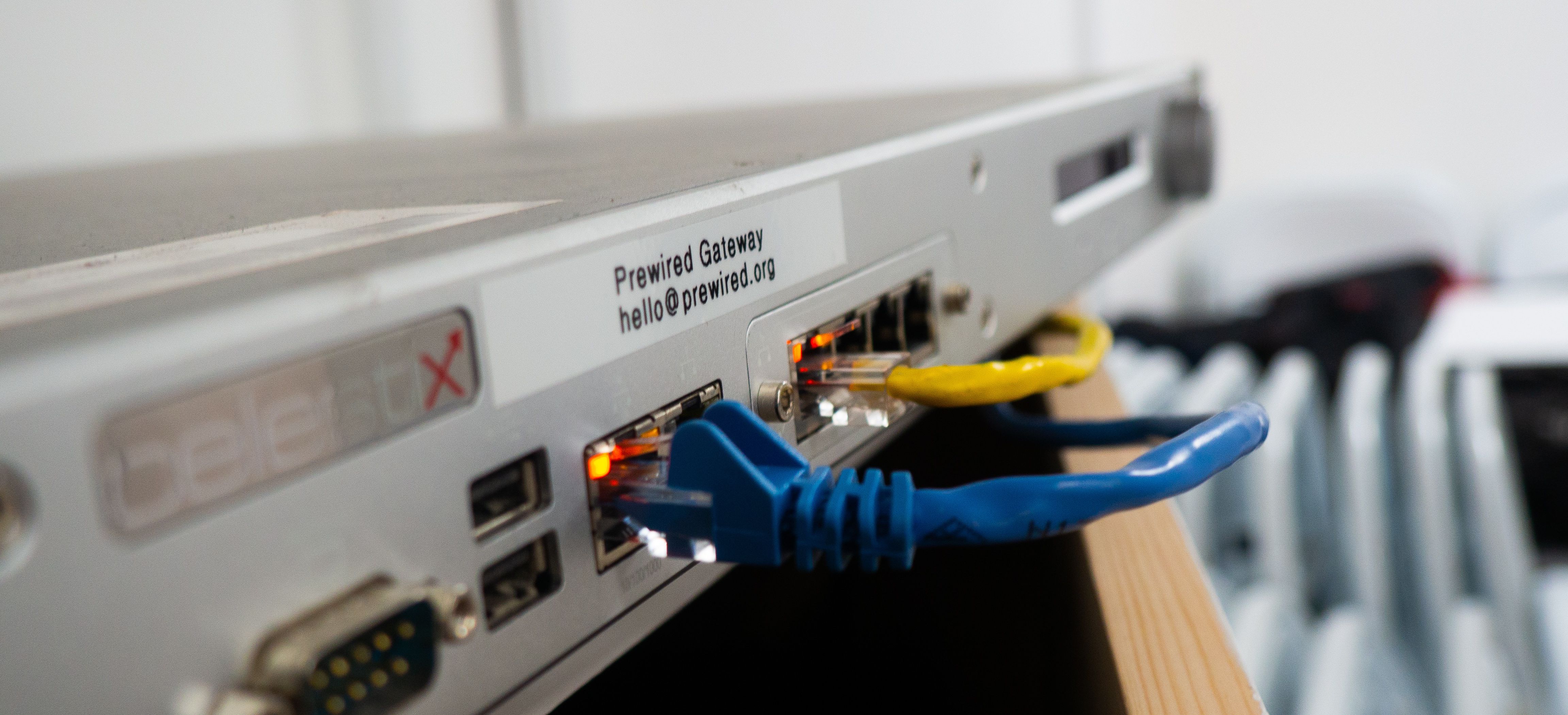 A young person programming a BBC micro:bit while a mentor is pointing at a screen