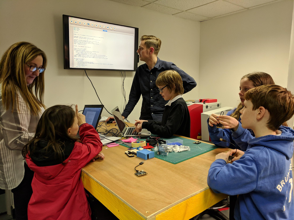 A Prewired attendee working with a laptop and a set of crafting materials